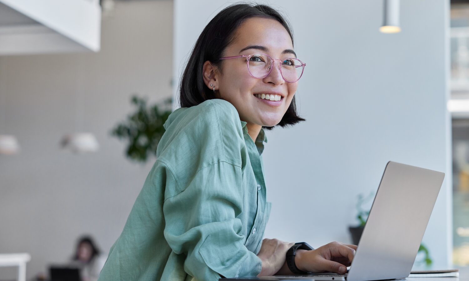 Person arbetar vid laptop i modern kontorsmiljö